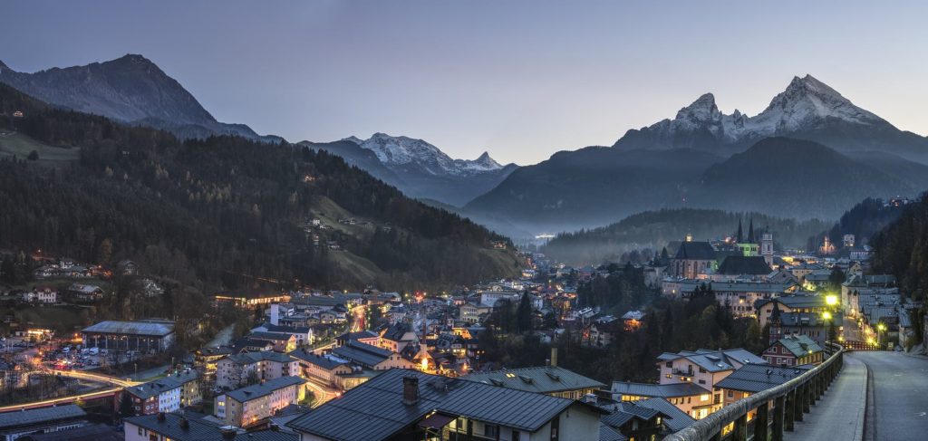 A serene mountain town illuminated under a clear twilight sky.