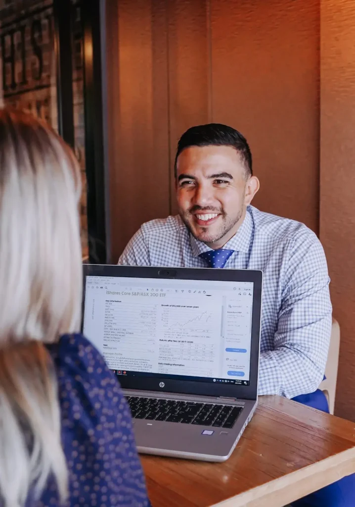 Financial advisors having a meeting with documents on a laptop in Brisbane.